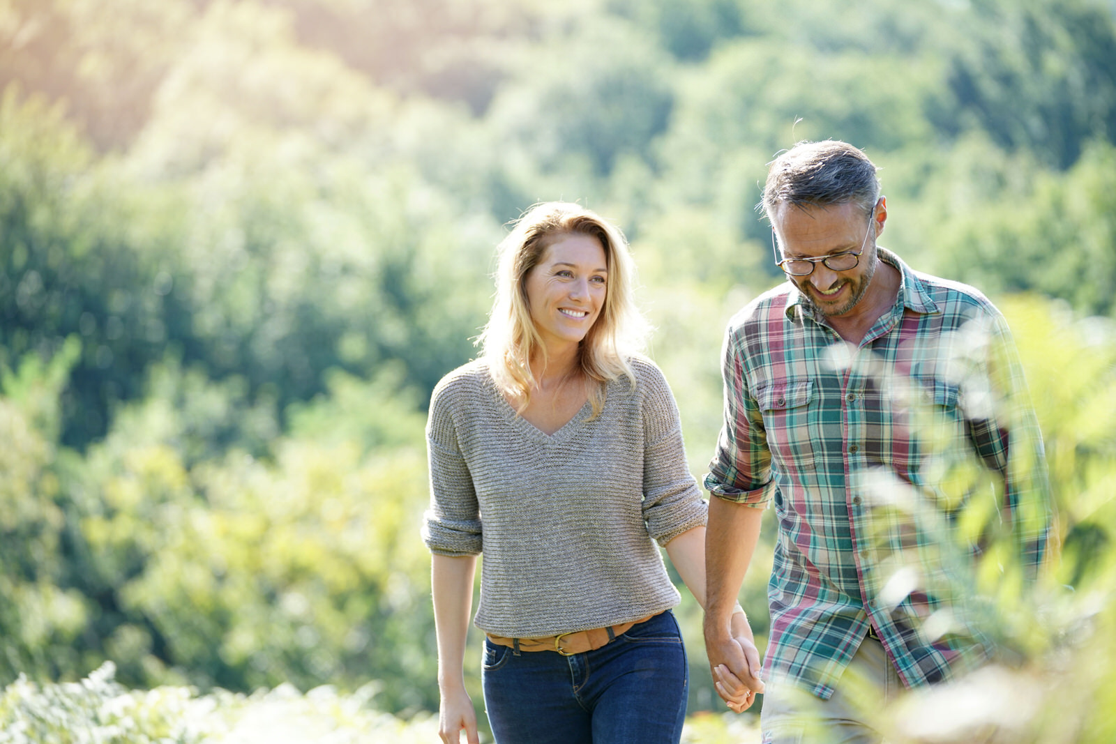 Happy,Mature,Couple,Walking,In,Countryside,On,Sunny,Day